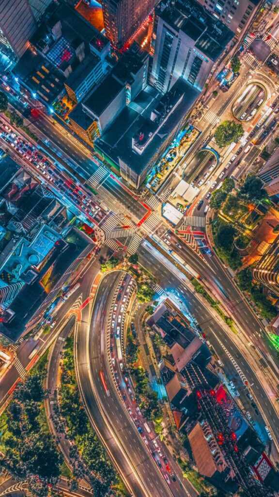 Colorful aerial view capturing the vibrant night city traffic intersection.
