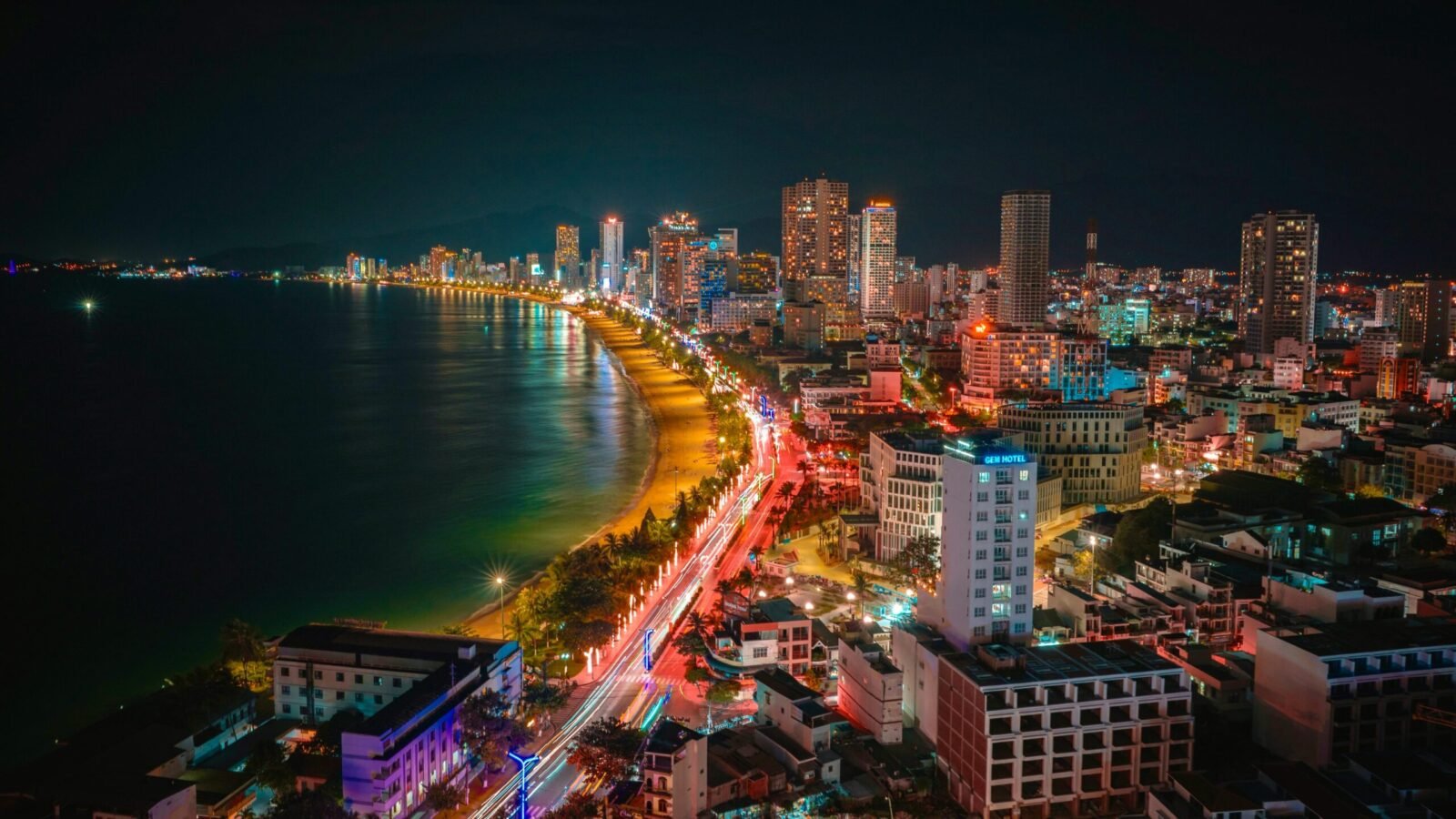 Aerial view of the illuminated coastline and cityscape of Nha Trang, Vietnam at night.